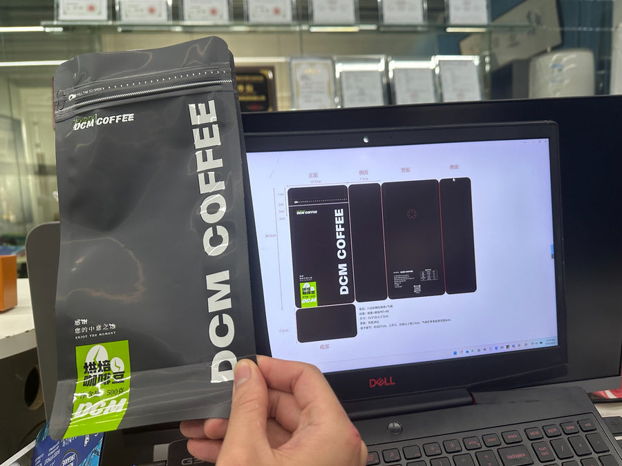Finished black DCM Coffee pouch beside its packaging artwork